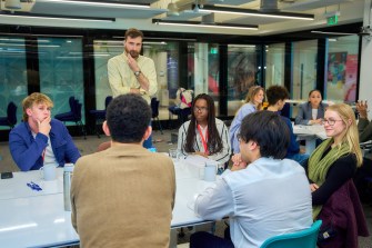 A group of Northeastern community members sitting around a table at a psychology conference.