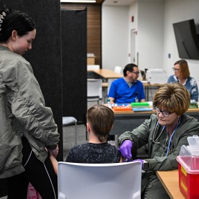 A medical staff member administering a measles vaccine.