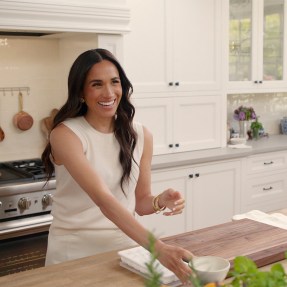 Meghan Markle, Duchess of Sussex, smiles while hosting in a kitchen during an episode of her Netflix series With Love, Meghan, part of her lifestyle brand launch.