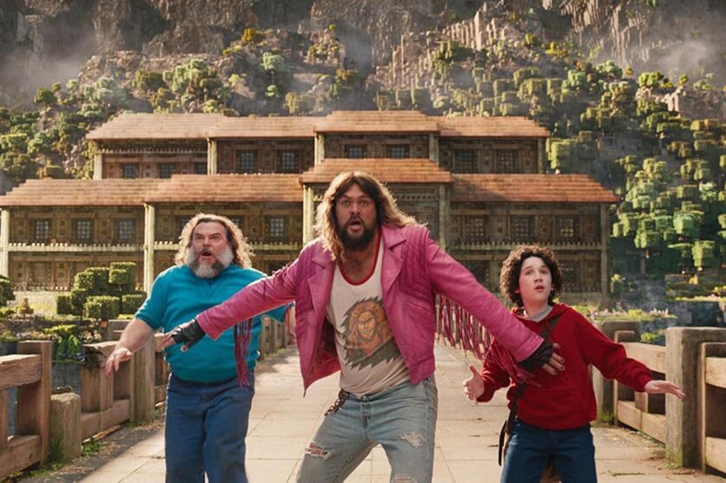 A screen capture of three characters from the 'Minecraft' movie standing on a bridge looking shocked.