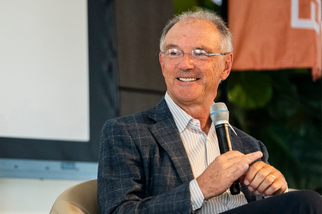 David Roux holding a microphone and smiling.