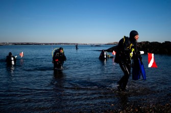 Students in dive gear leaving the water in Nahant.