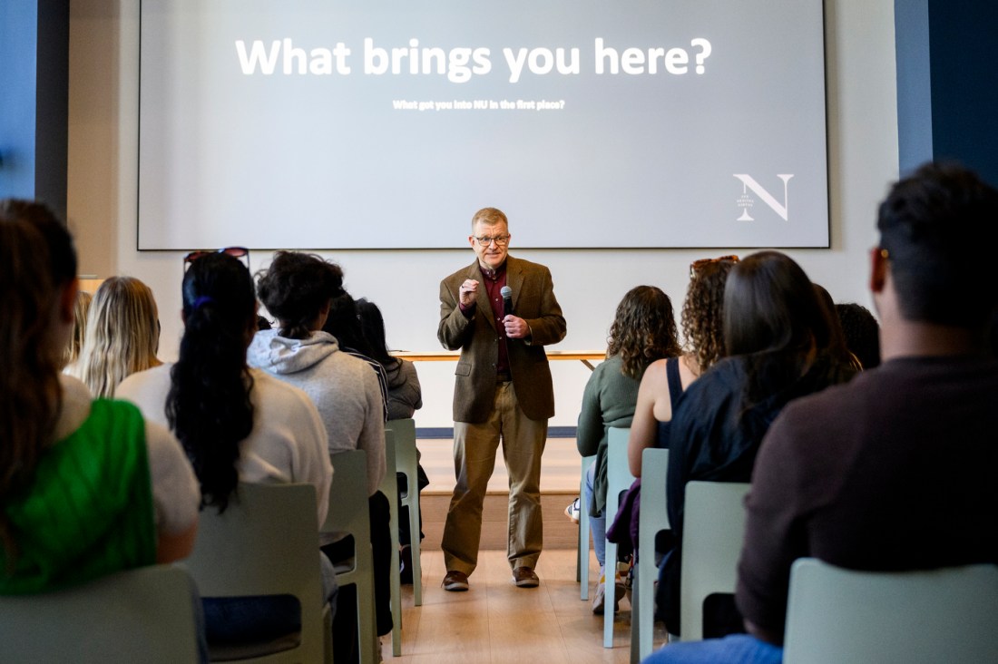 William Sharp standing in front of a room of audience members speaking into a microphone.