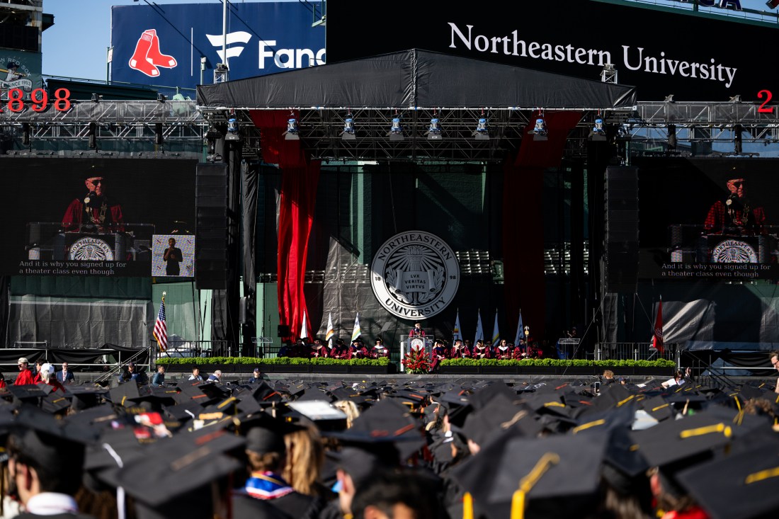 Wide view of the Commencement stage setup at Fenway Park with speakers addressing the audience.