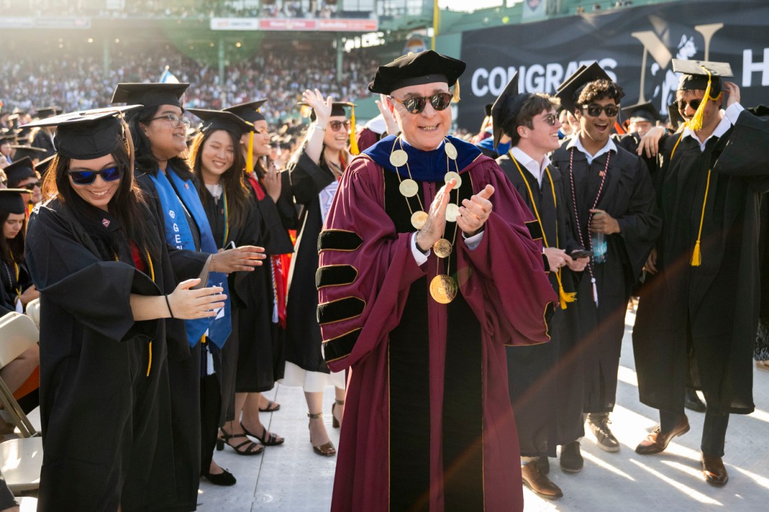 Graduates toss caps into the air during the 2025 Commencement ceremony at Fenway Park.