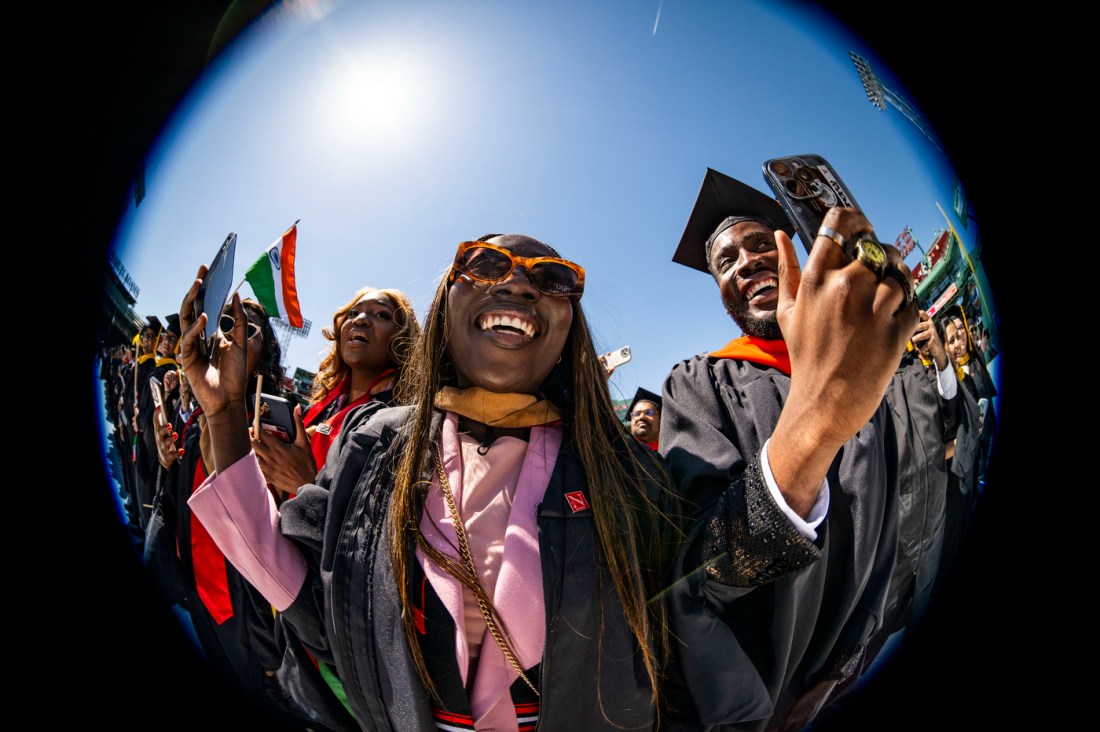 Graduates celebrate and take selfies during Commencement at Fenway Park.