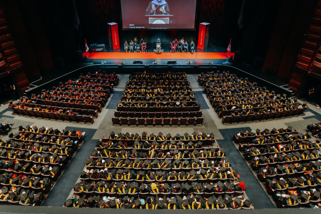 A wide angle shot from above of rows of graduates and audience members in Meridian Hall for the Toronto graduation.