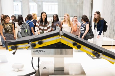 Students gathered around an exhibit of a medical device in the Science Museum in London.
