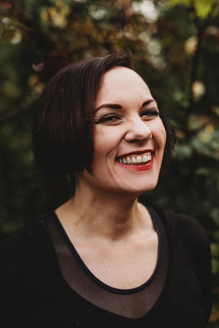 Erin Clair, a Northeastern dean, featured smiling against a leafy backdrop.