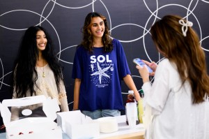Sameerah Nawaz and Nishita Vyas, two Northeastern students and members of the Happiness Club, smile and hand out cupcakes during a campus event.