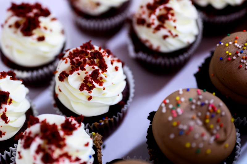 A close-up of two different kinds of cupcakes, one with vanilla frosting, the other chocolate frosting.