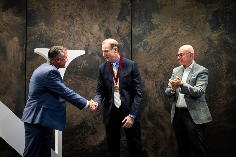 Charles Hillman shakes hands with Todd Manganaro as President Aoun claps.