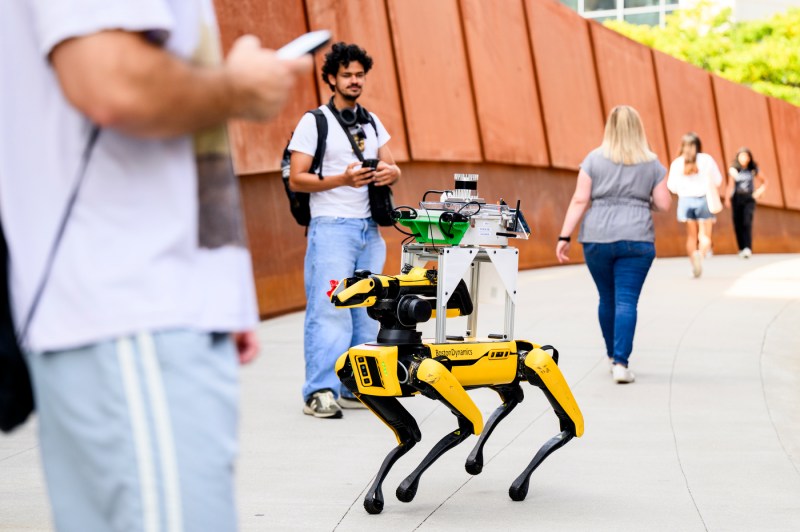 Students test robots outside on a bridge on the Boston campus.
