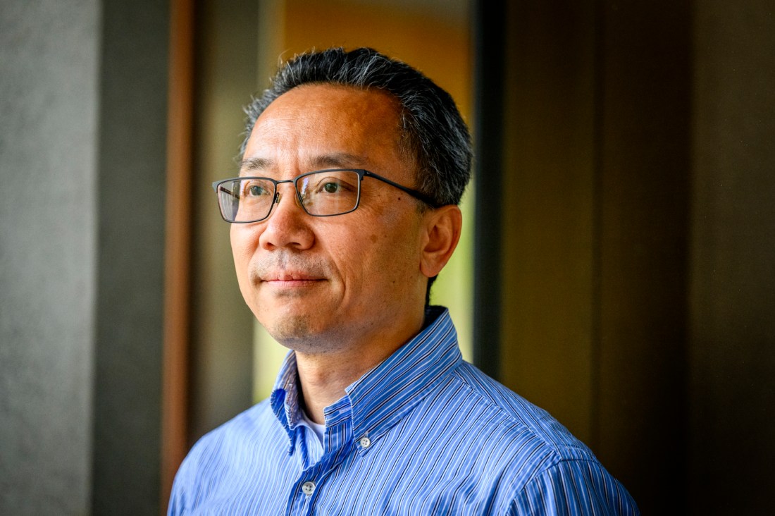 Kelvin Liu, a middle-aged Asian man with short hair, looks off into the distance with a neutral expression.