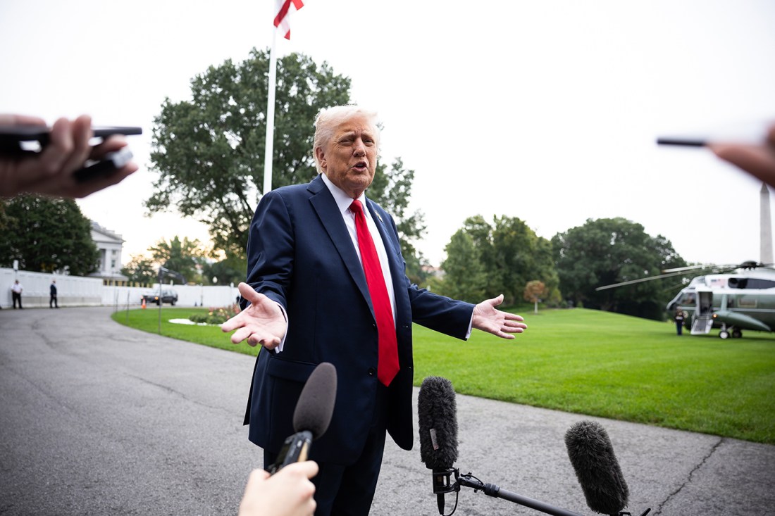 Donald Trump shown gesturing during a press conference in front of reporters.