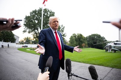 Donald Trump shown gesturing during a press conference in front of reporters.