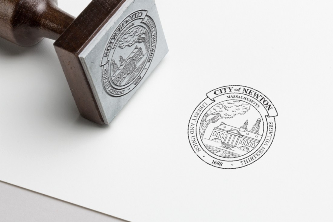 A metal tool with an engraving of the City of Newton seal on it.