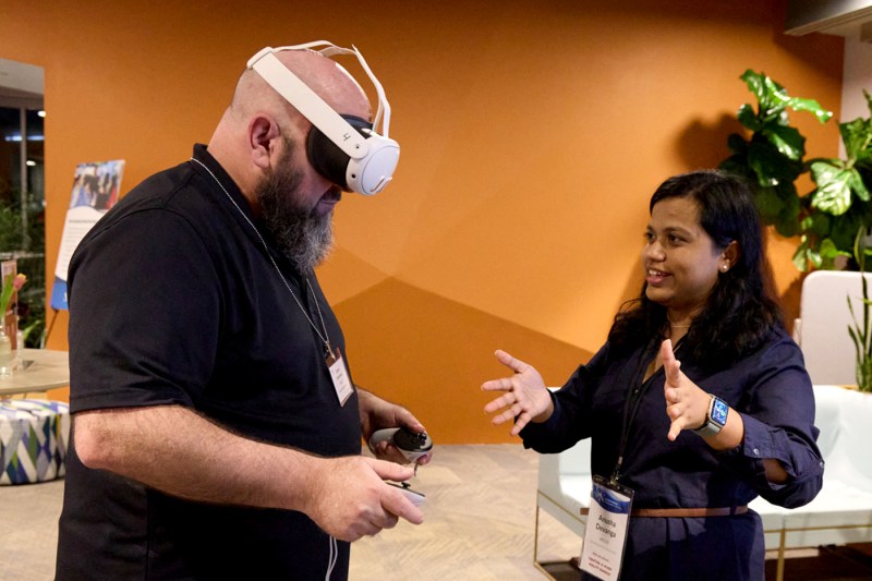 Person wearing a VR headset receives guidance from an instructor during a technology demonstration at the Roux Institute.