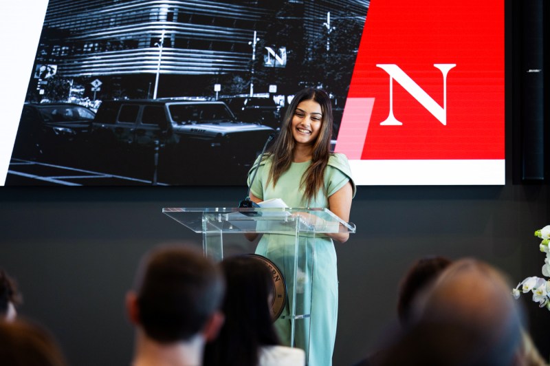 A speaker smiles at the podium during Northeastern’s fireside chat with General Catalyst CEO Hemant Taneja in EXP on Oct. 6, 2025.