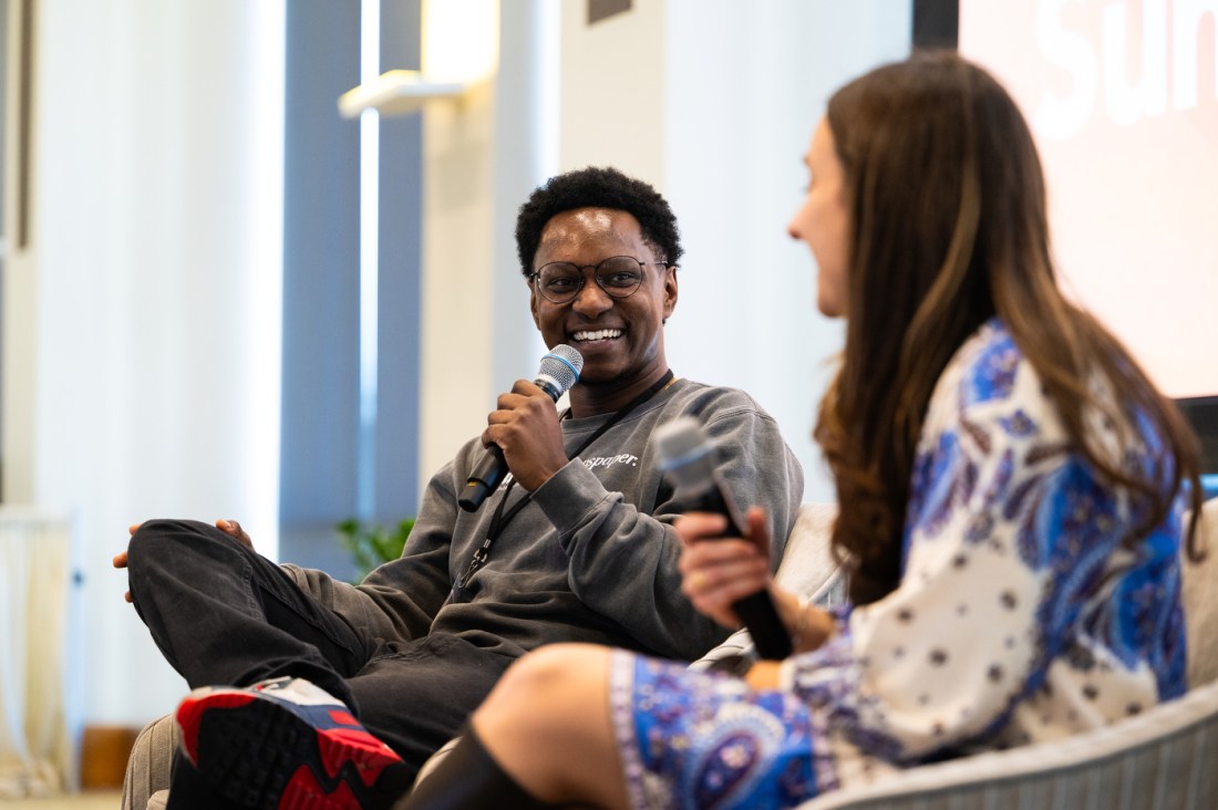 Joseph Ferguson and Michaela Quigley sitting on stage both holding microphones at the Social Media Summit.