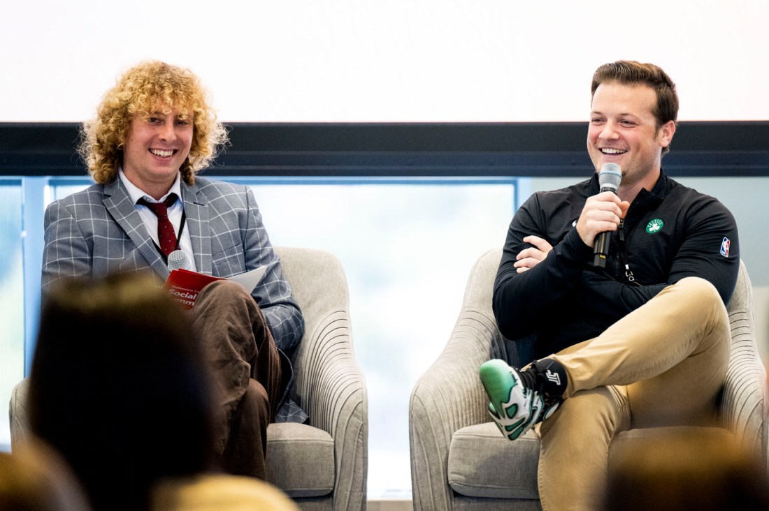 Cameron Sleeper and Mike Sivo sitting next to each other in grey chairs on stage at the Social Media Summit. 