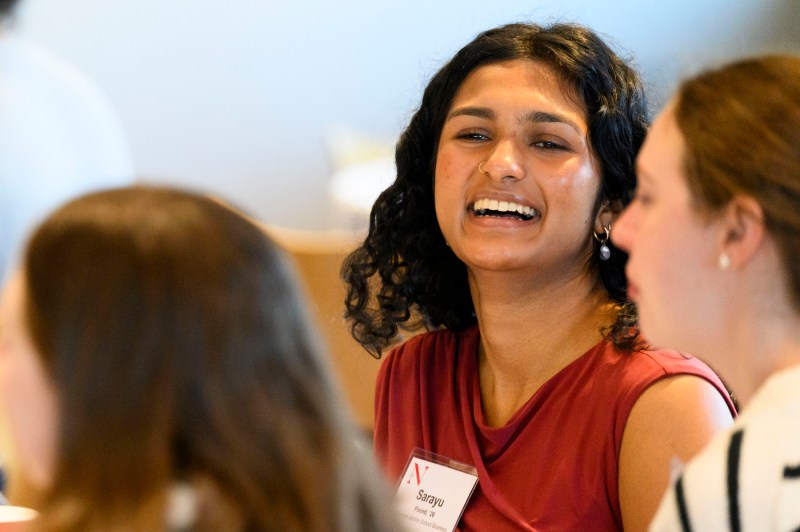 A female audience member laughs while in conversation with two attendees during the community-building brunch.