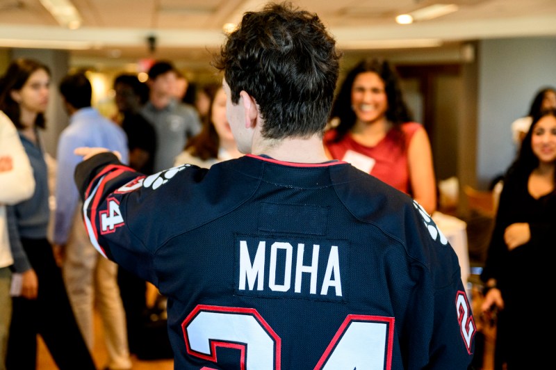 Sam Iannone, the Mayor of Huntington, donned in a Husky jersey, points to an attendee during a mixer held in the Alumni Center.
