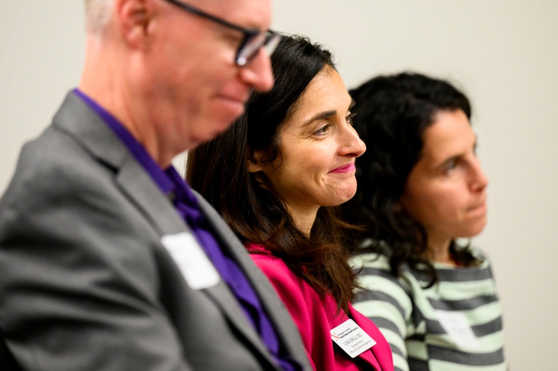 Audience members smile while listening attentively at the Fall River campus grand opening. 