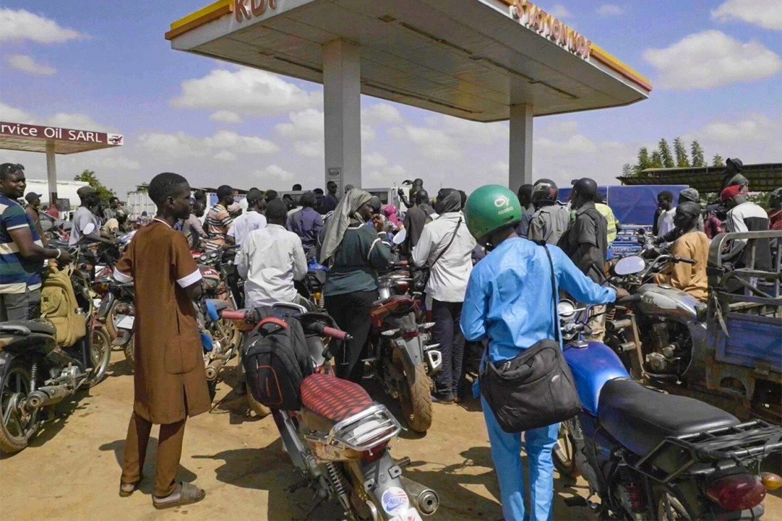 People queue with their motorcycles at a gas station amid a fuel shortage in Bamako Mali.